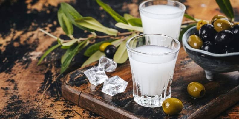 The image shows 2 glasses of ouzo